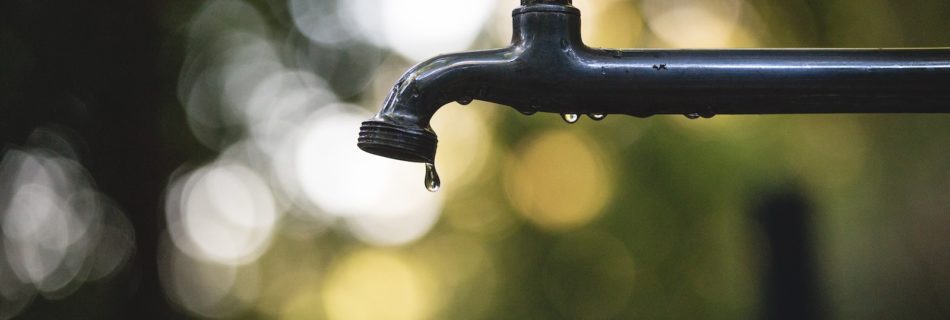 tilt shift lens photography of black steel faucet