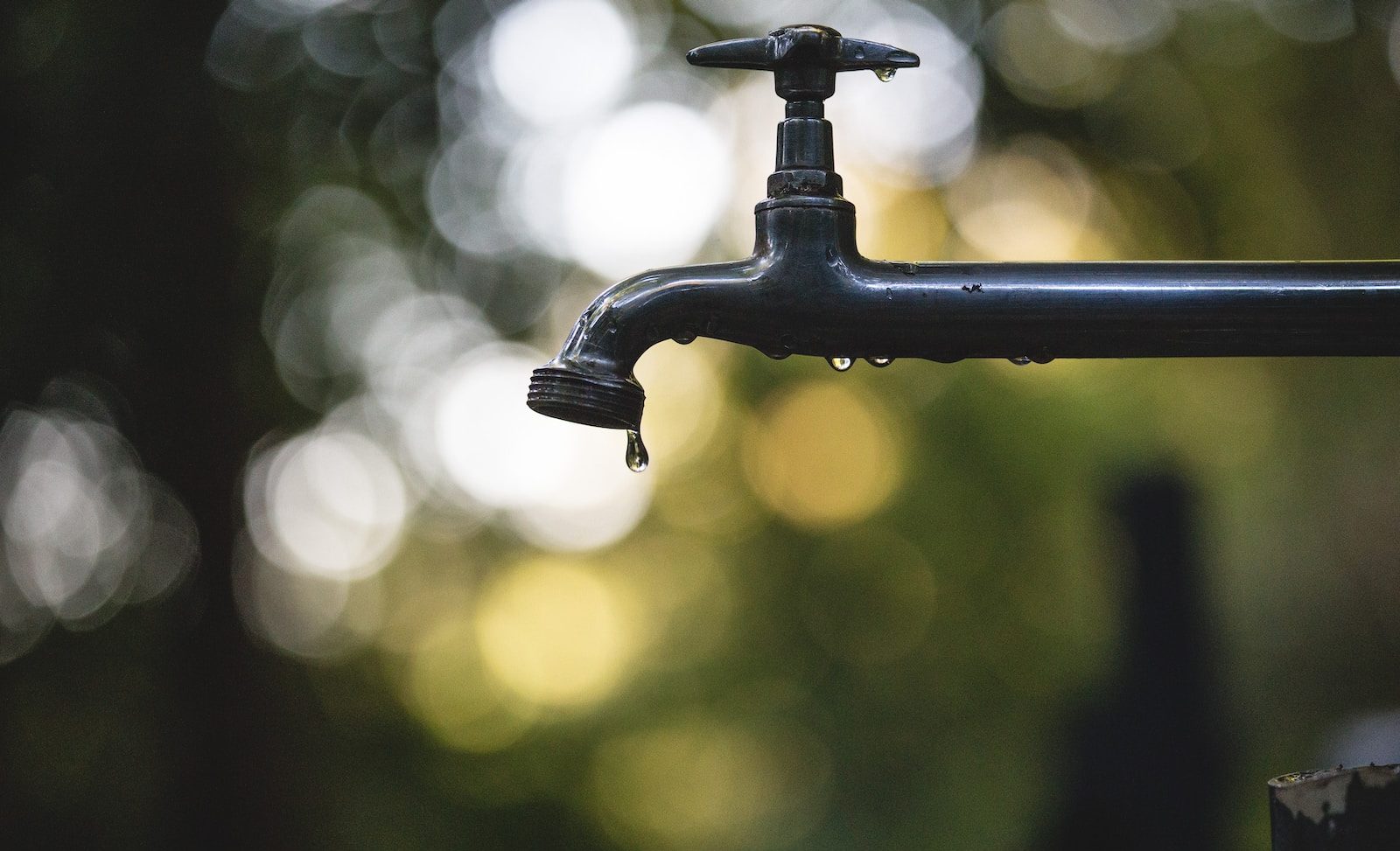 tilt shift lens photography of black steel faucet